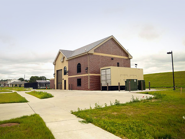 Finished Perkett Ditch Pump Station in Minot, North Dakota—engineered to resemble a neighborhood home, blending essential flood infrastructure into the community landscape.