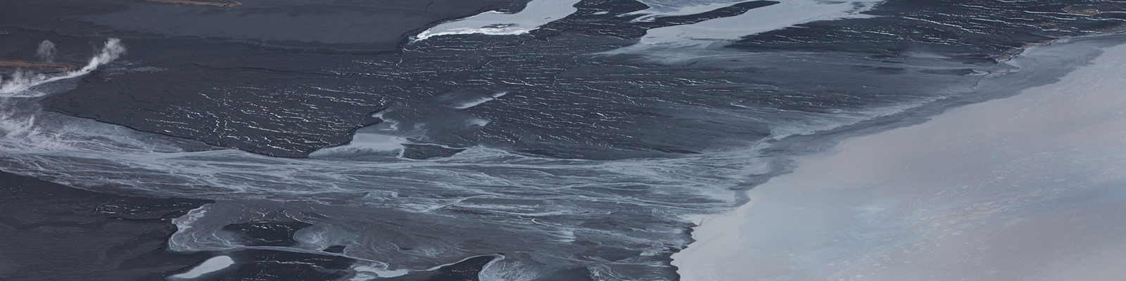 Crude oil seen separated from sand for collection. Tailings ponds are used to separate the heavy oil bitumen from the sticky sand mined from around the area near Fort McMurray, Alberta.