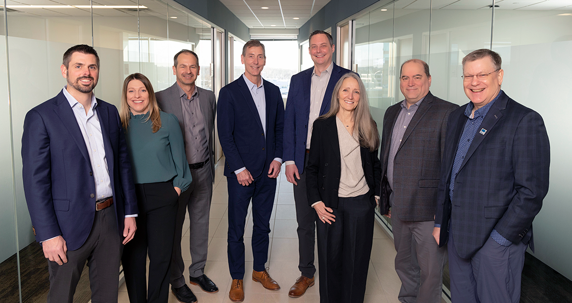 A group photo of the eight members of Barr's management team