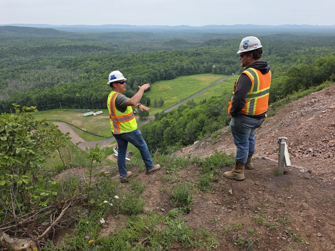 Two engineers conduct a survey on the landing hill of the Copper Peak ski jump.