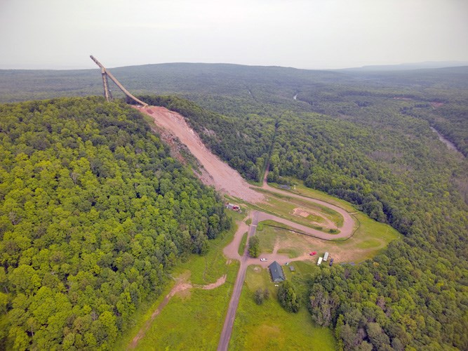 Two engineers talking on a steep hillside at Copper Peak in Michigan