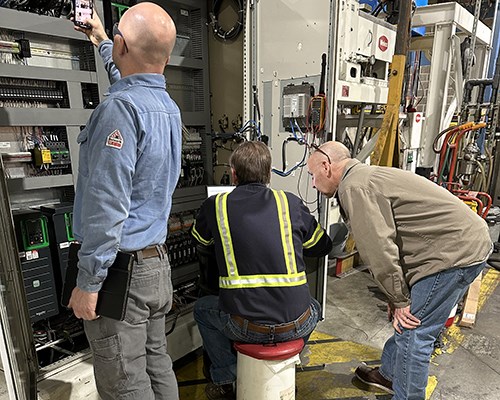 Industrial machine with a large yellow circular component and a central shaft, featuring a Welex control panel with touchscreen display, in a well-lit factory setting.