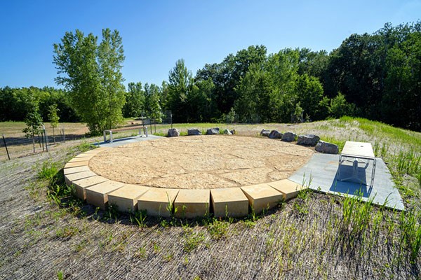 An artificial channel made of layered stones beneath a small bridge.