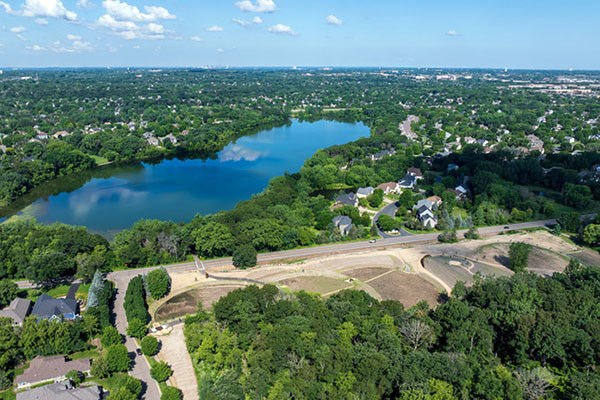A stone patio and bench at the top of a hill at a park.